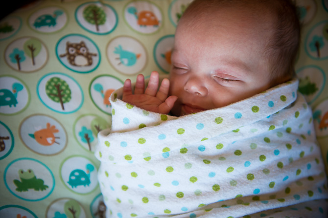 Sleeping newborn closeup, waving.
