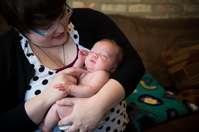 Still asleep, in his mom's arms.