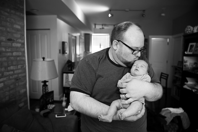 Dad kissing his newborn son.